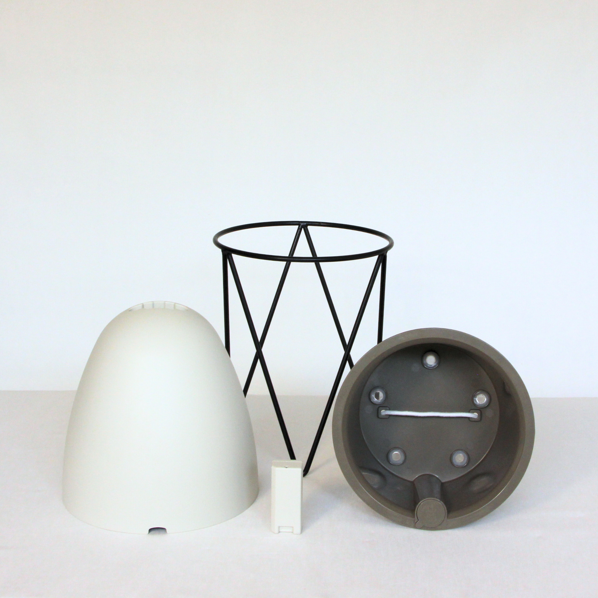 The Egg taken apart: the outer shell, the black iron stand and the water level sensor